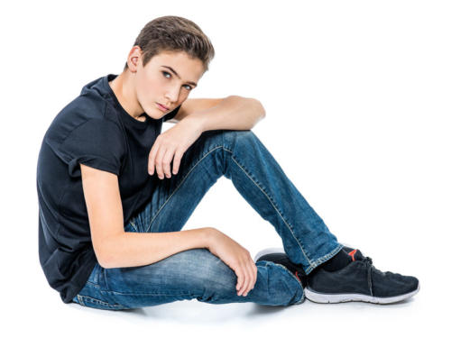 Photo of teenage handsome guy posing at studio